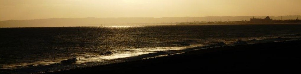 La plage de Lion sur Mer sous les lumières tamisées du soleil levant.
